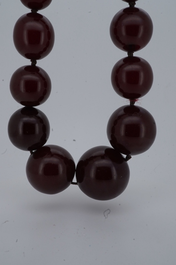 A cherry bakelite 'amber' necklace, composed of graduated spherical beads measuring approximately 6.7-23mm diameter, length approximately 86cm, gross weight 72 grams.